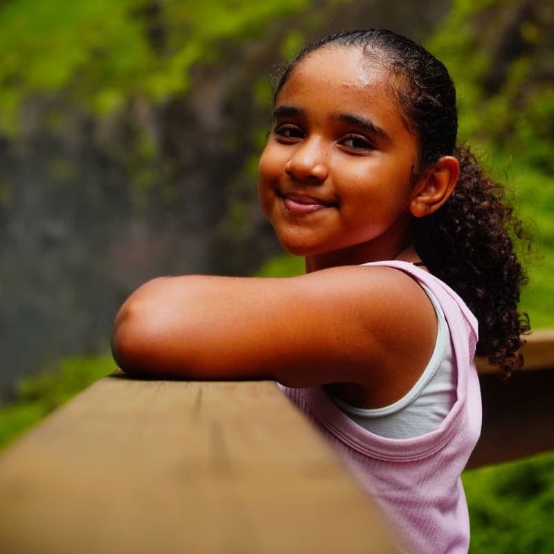 Menina sorrindo em ensaio no Pé da Cascata do Caracol