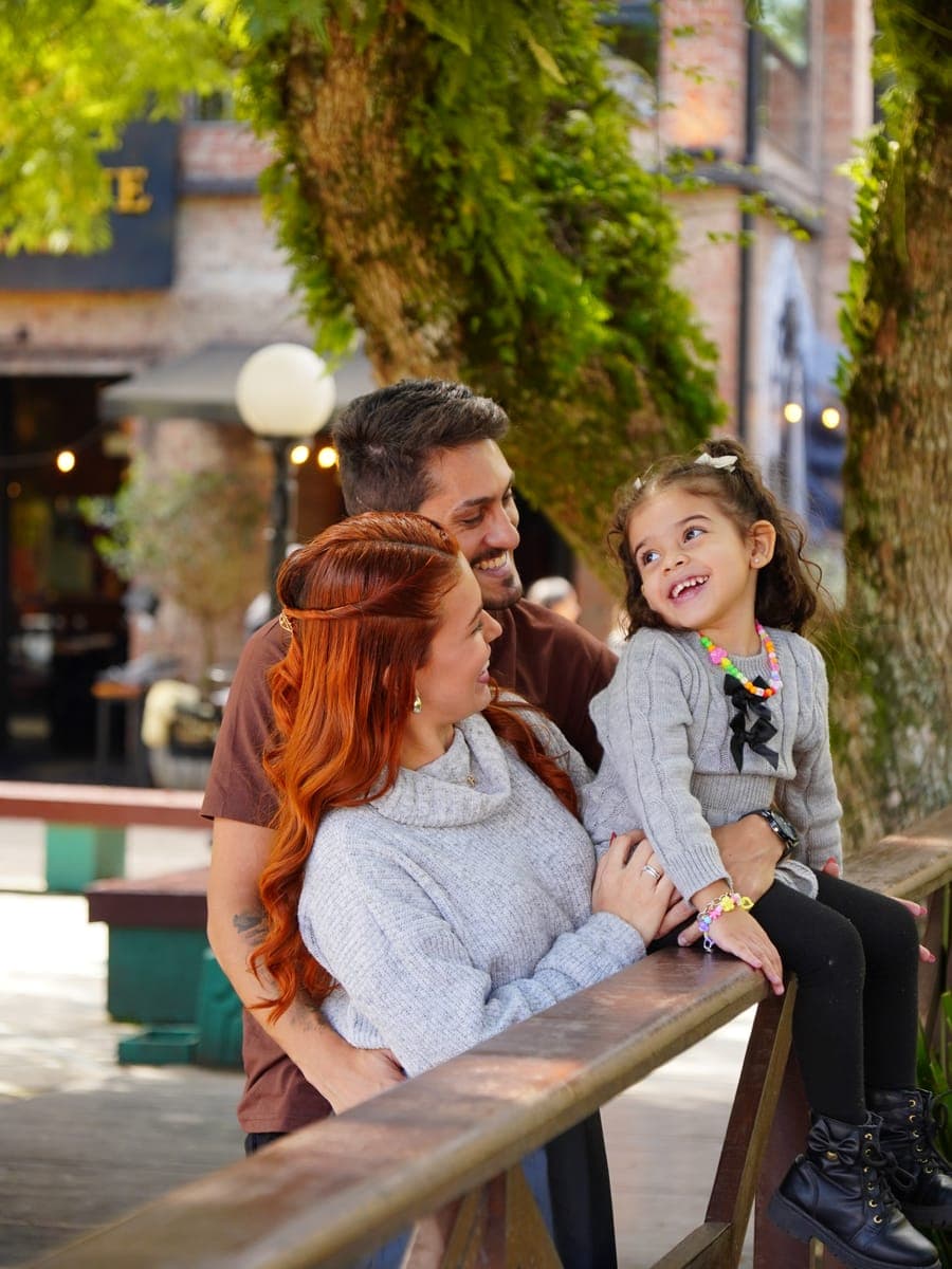 Família sorrindo em ensaio no centro de Gramado